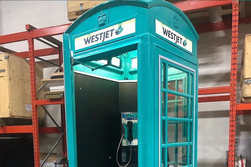 close up of the top half of a teal london-style phone booth, branded for an experiential marketing event