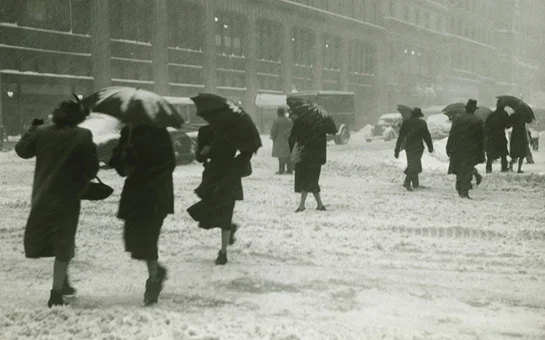 black and white image of pedestrians in a stormy urban winter setting.
