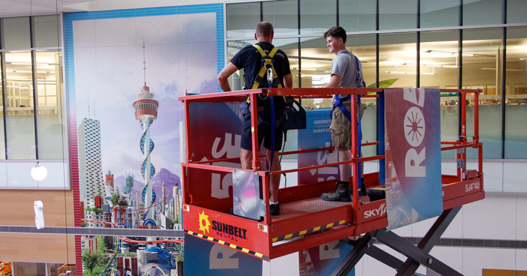 crew installing a large-format print display in Calgary, Alberta for an interpretive exhibit.