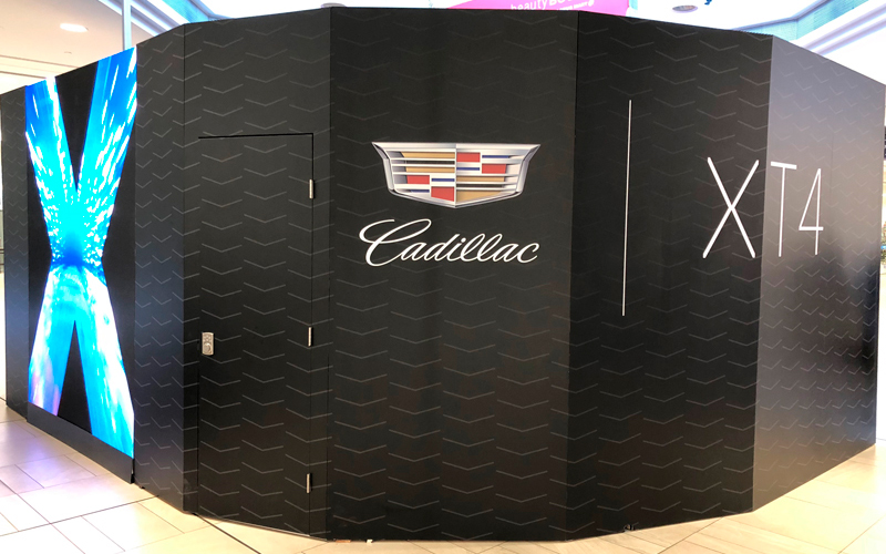 backside of the curved video monitor wall that seamlessly features a locking door that leads to internal storage. Branded graphics cover the entire display and wall.