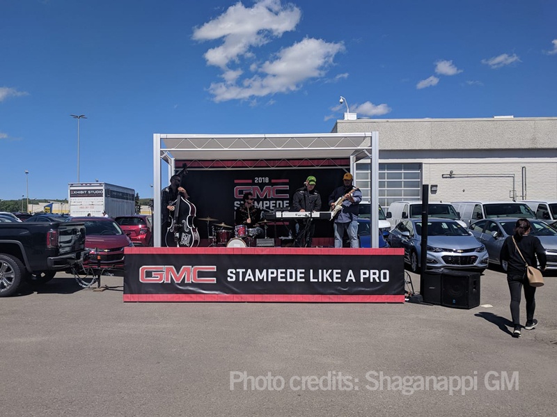branded outdoor band stage with overhead shelter and vinyl banner