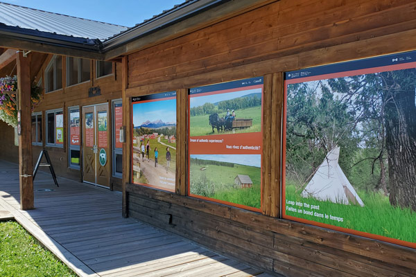 bar u ranch national historic site window graphics on the exterior of a wooden building. The images show colourful pictures of the ranch in Alberta