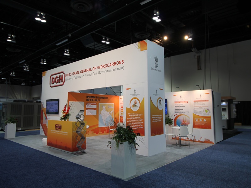 20x20 custom modular trade show booth for the Global Petroleum Show in Calgary, Alberta. The booth includes a back wall with a built-in storage room, and tall wall panels with an overhead canopy showcasing the company logo. Underneath this archway you can walk into a meeting area with multiple tables, chairs, and tv monitor. Infographic wall decals are included, and a branded reception counter sits at the front of the booth.