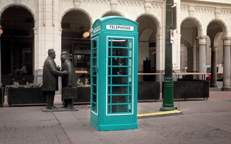 a teal-coloured branded phone booth for Westjet set up in Downtown Calgary. 