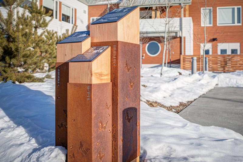 outdoor donor recognition monument designed and built in Calgary, Alberta. Each angular pillar features an informational plaque on the top, which rests on wooden posts surrounded my engraved metal casings.