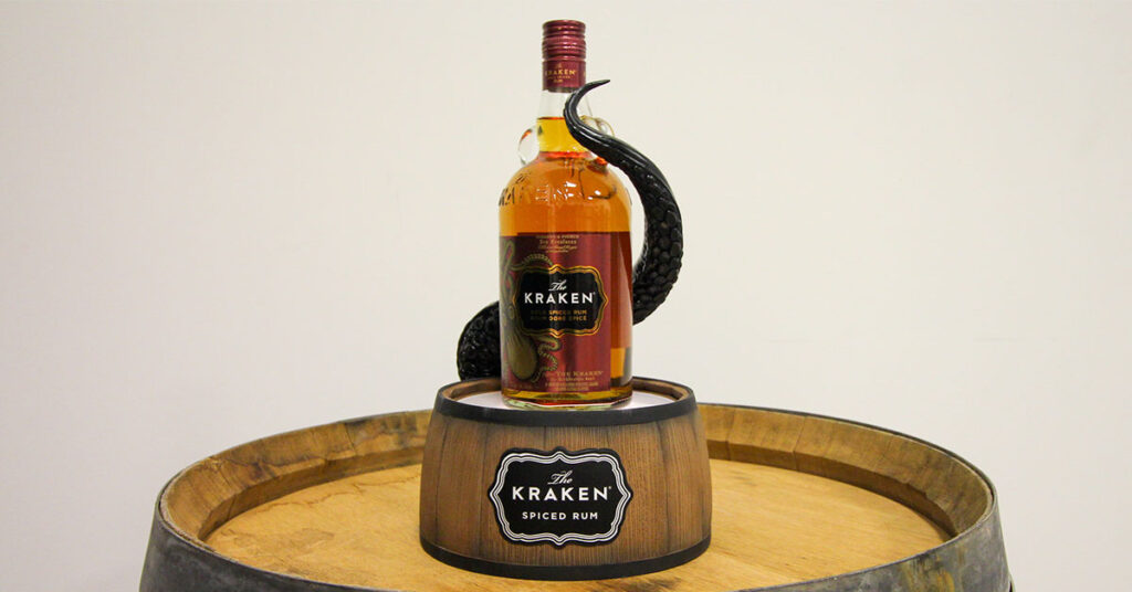 custom Kraken Rum liquor bottle display, sitting on an illuminated barrel with a tentacle wrapping around the bottle.