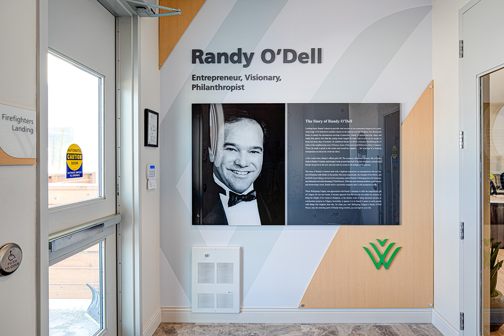 branded office wall with a dimensional panel of the founder and their story for Wellspring in Calgary. 