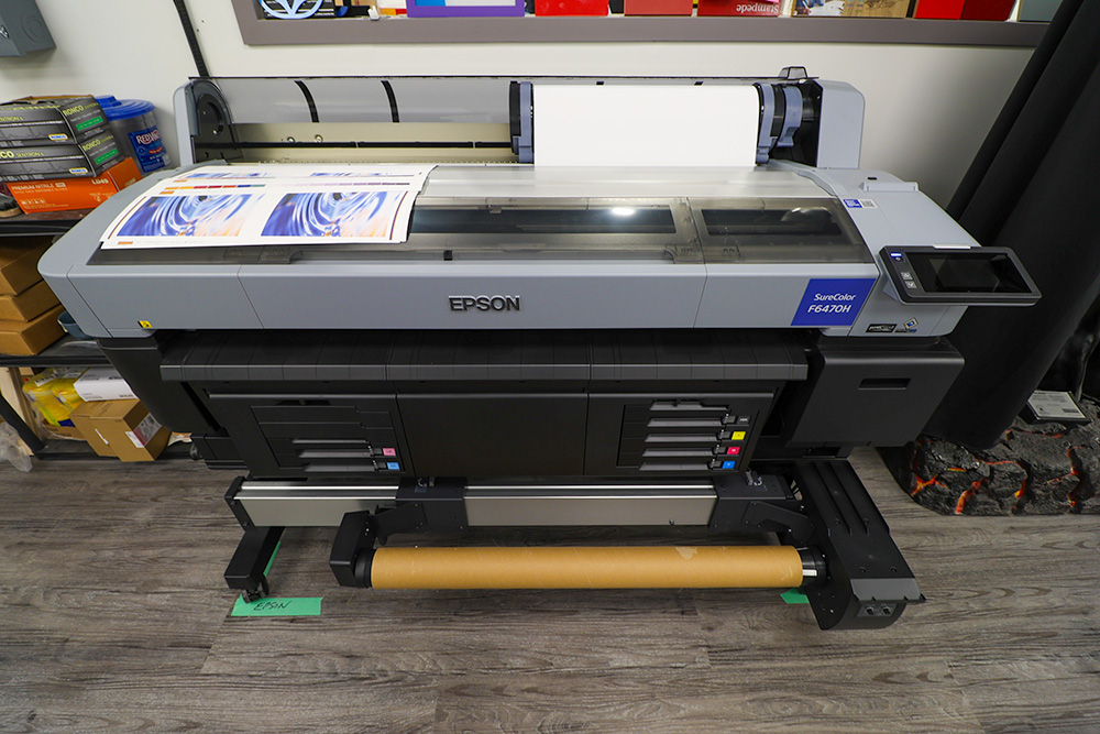 large format dye sublimation printer at our Calgary design studio. The printer prints onto a specialized heat-transfer paper that bonds to the material during the hat transfer process. 