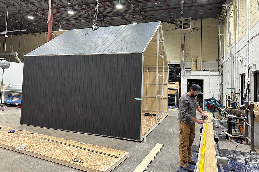 sagiper_customFabrication_tradeShow custom fabricated a-frame trade show display being constructed in a shop in Calgary. the exterior material is a dark grey siding with aluminum framing.